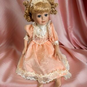 Vintage Porcelain Sitting Doll – Blonde Hair, Brown Eyes, Peach Dress –